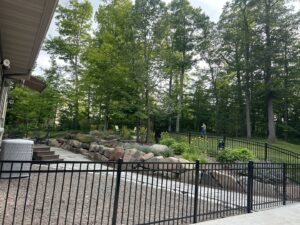 A black metal fence integrated into a beautiful backyard landscape by North Shore Fence Company in Centereach, NY.