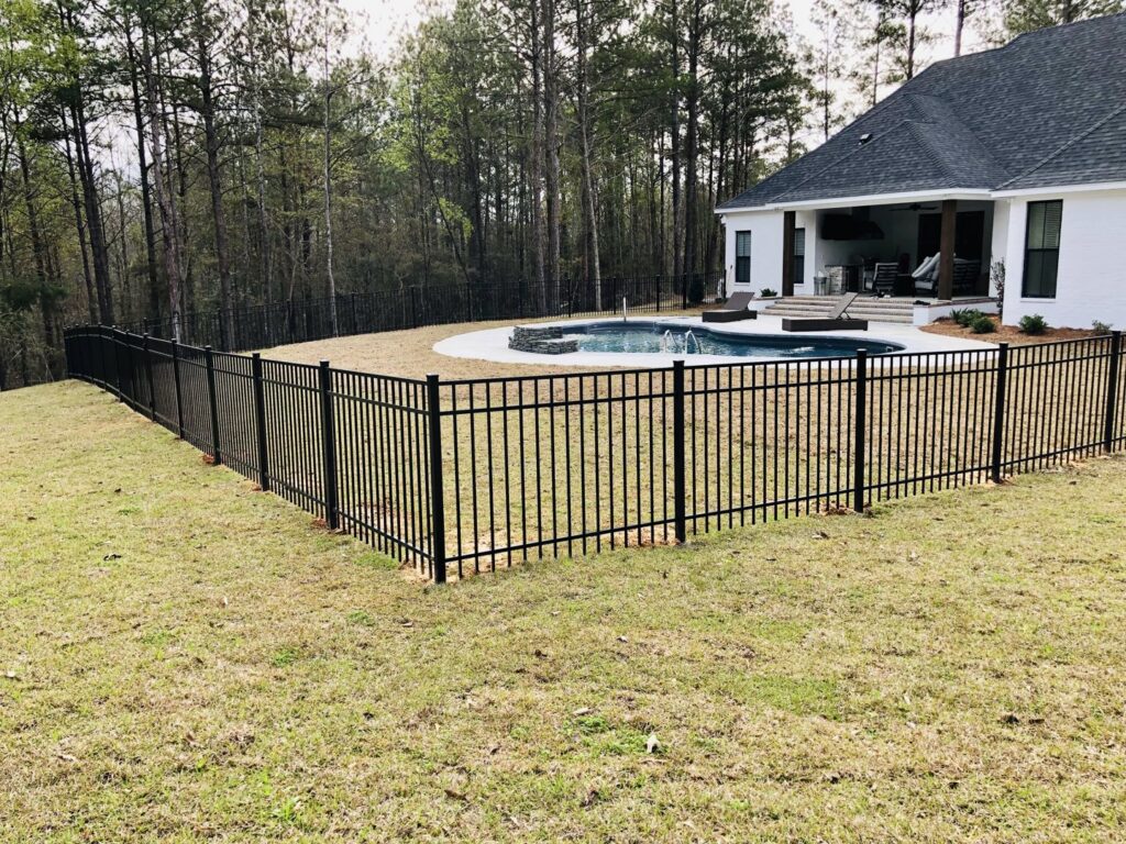 A black metal fence installed around a backyard pool area by Jefcoat Fence Co. Inc. of Hattiesburg, MS