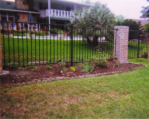 A black metal fence with a decorative brick pillar installed by City Fence Co of San Antonio, TX