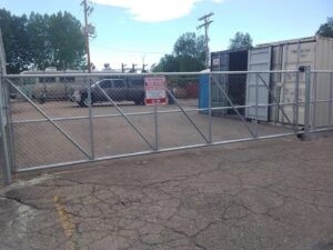 A stylish black metal fence with integrated brick pillars and a gate, enhancing security for a commercial property by Best Boy's Fencing in Fort Collins, CO.