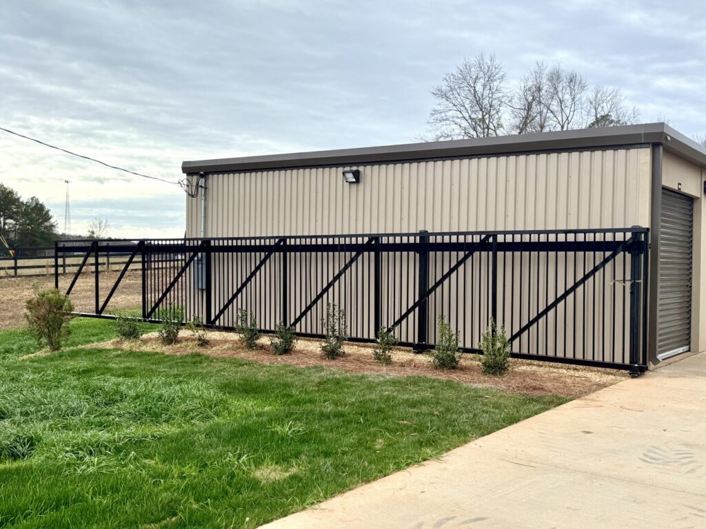 A black metal fence installed next to a commercial building by Creative Fence Designs in Columbus, GA.