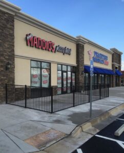 A black ornamental metal fence enclosing a commercial outdoor patio area for a restaurant by Georgia Select Fence in Senoia, GA.