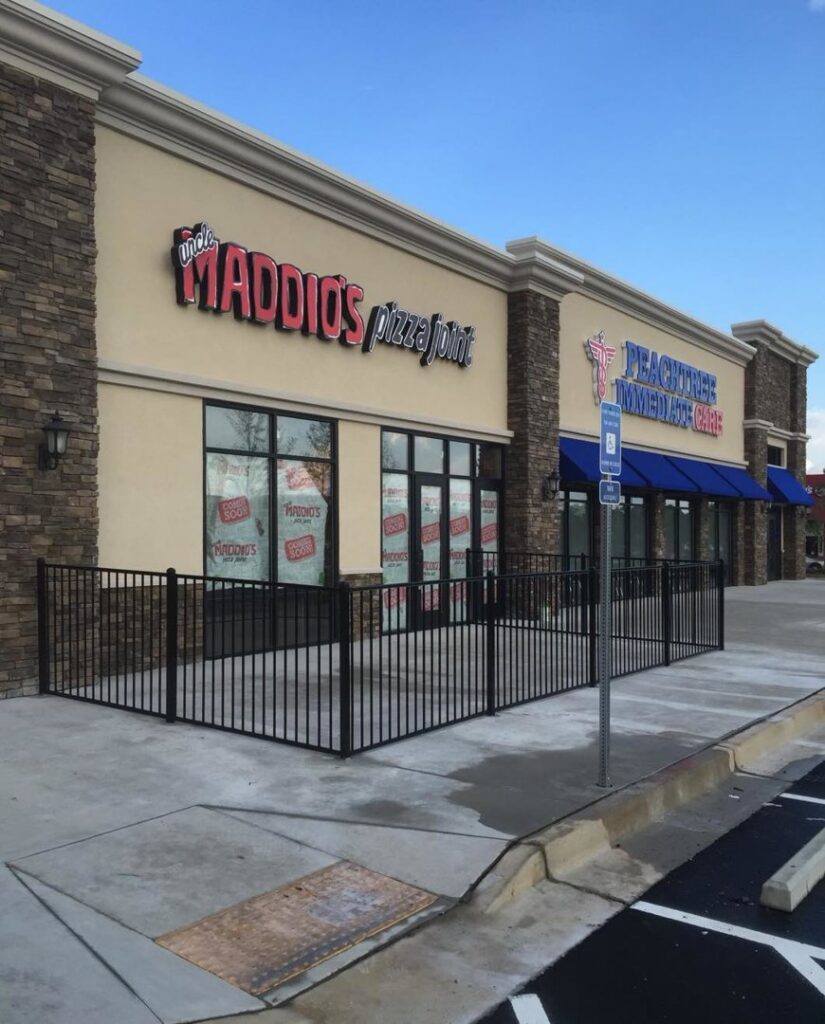 A black ornamental metal fence enclosing a commercial outdoor patio area for a restaurant by Georgia Select Fence in Senoia, GA.