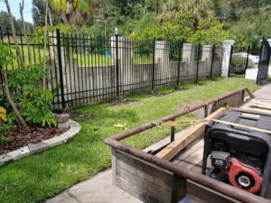 A black metal fence with decorative concrete pillars and a gate, installed by Big Jerry's Fencing of Boise ID in Holly Springs, NC.