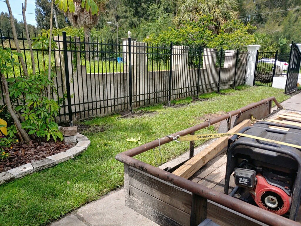 A black metal fence with decorative concrete pillars and a gate, installed by Big Jerry's Fencing of Boise ID in Holly Springs, NC.
