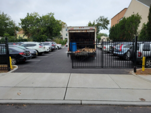 A newly installed black metal fence and gate securing a parking lot by Fox Fence Enterprises Inc in Clifton, NJ.