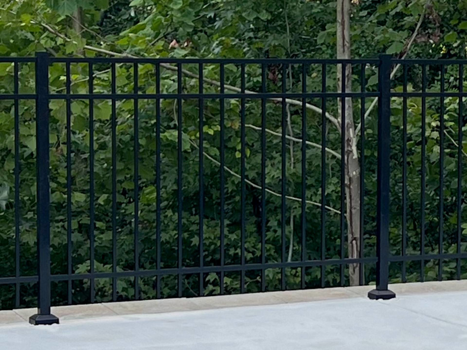 A sleek black metal fence installed by First Class Fence and Landscape LLC in Birmingham, AL, possibly for a pool or patio.