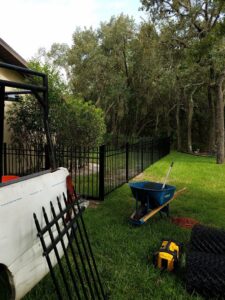 A newly installed black metal fence with construction tools nearby, completed by Aarons fence in Homosassa Springs, FL