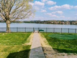A black metal fence with a gate providing lake access, installed by Morton Fence Solutions LLC in Indianapolis, IN.