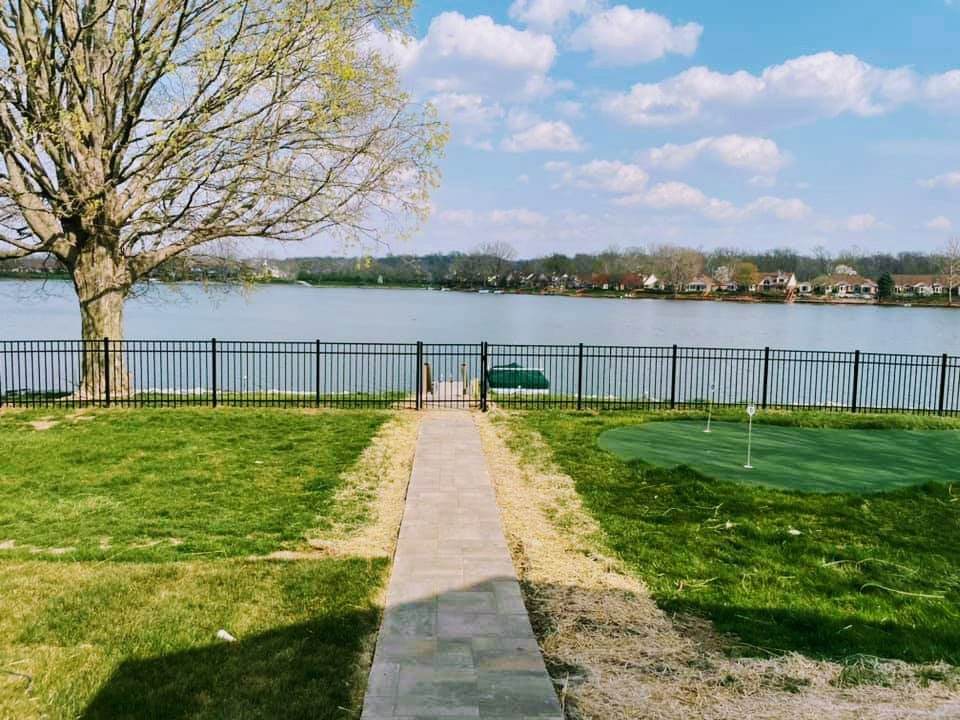 A black metal fence with a gate providing lake access, installed by Morton Fence Solutions LLC in Indianapolis, IN.