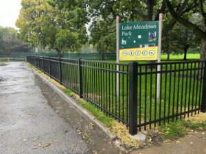 A black metal fence installed along a path in Lake Meadows Park by Superior Custom Fence Inc. in Chicago, IL.