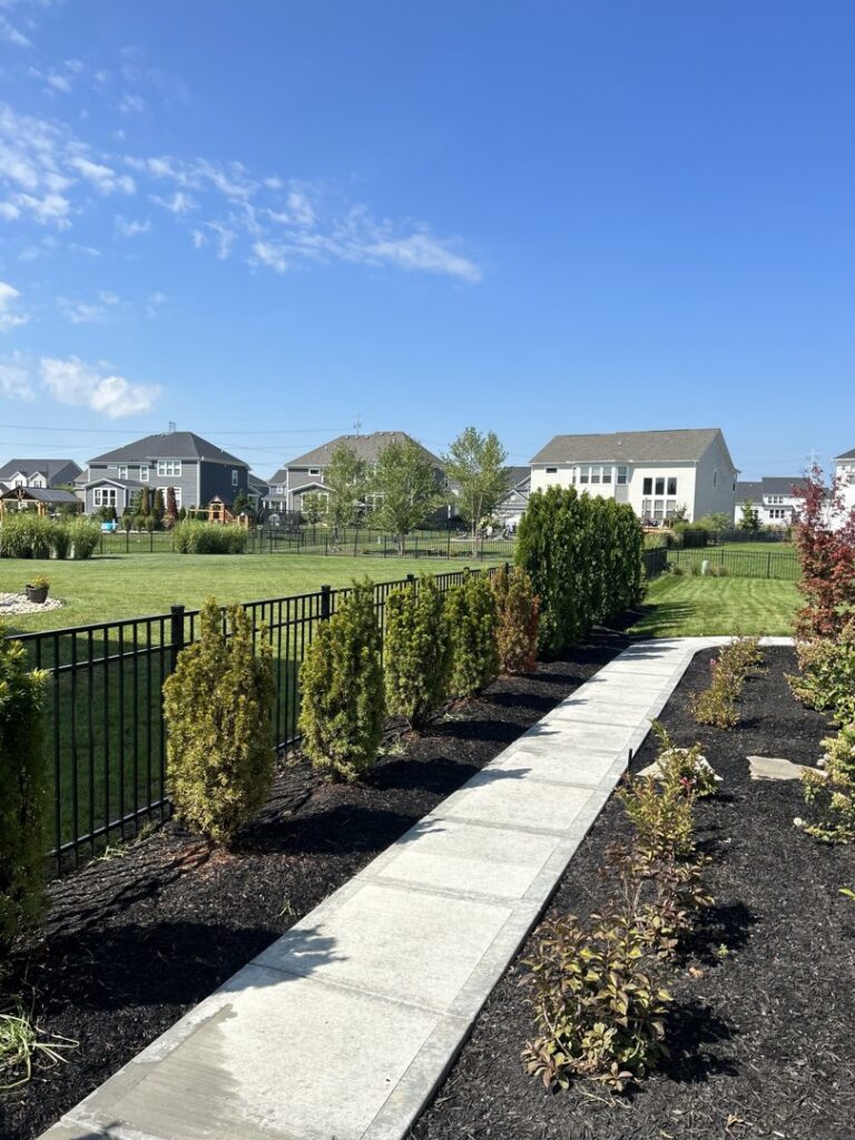 A sleek black metal fence bordering a landscaped sidewalk, installed by ReliableFencing in Columbus, OH.