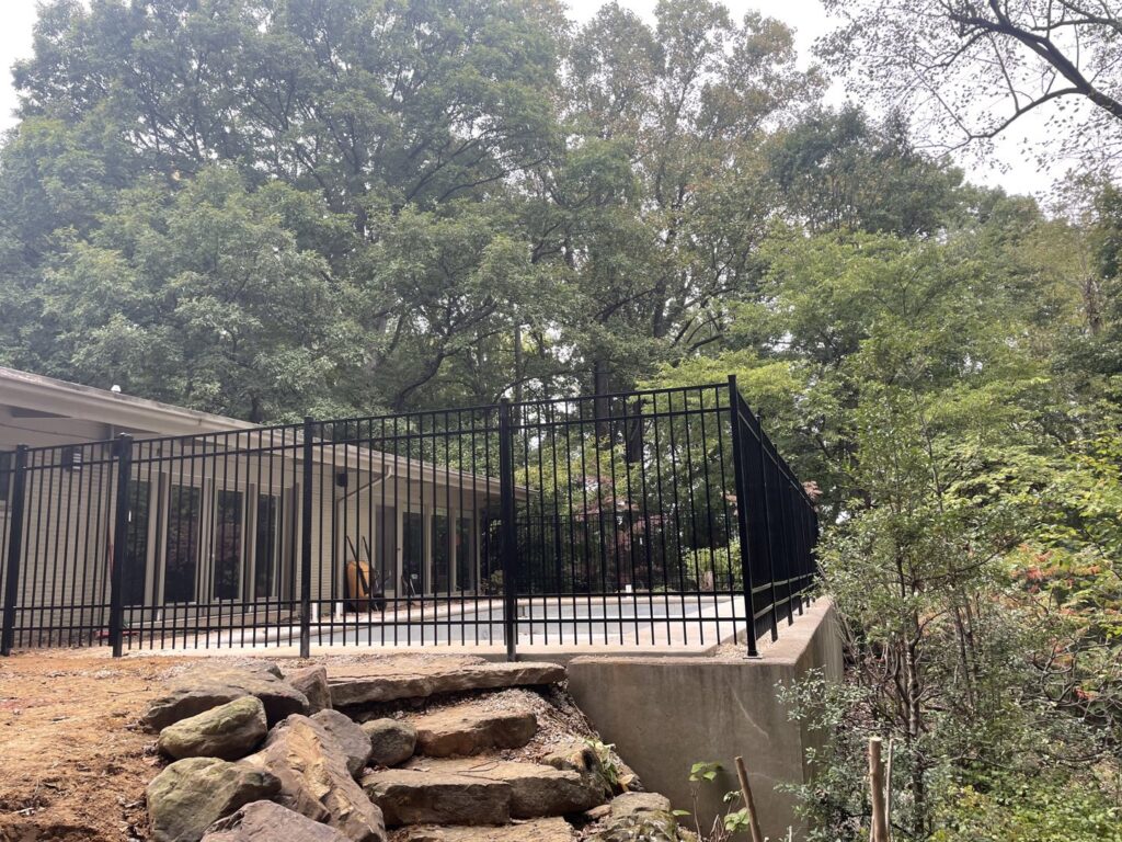 A black metal fence enclosing a patio area, installed by Quality Deck & Fence LLC in Owensboro, KY