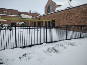 A black metal fence installed around a playground by Aces Deck and Fence, LLC in Fargo, ND.