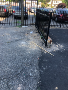 A close-up view of a black metal fence post during an installation or repair by Fox Fence Enterprises Inc in Clifton, NJ.