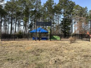 A newly installed black metal fence marking a property boundary by Lynch's Temporary Fencing & Dumpster rental in Bossier City, LA.