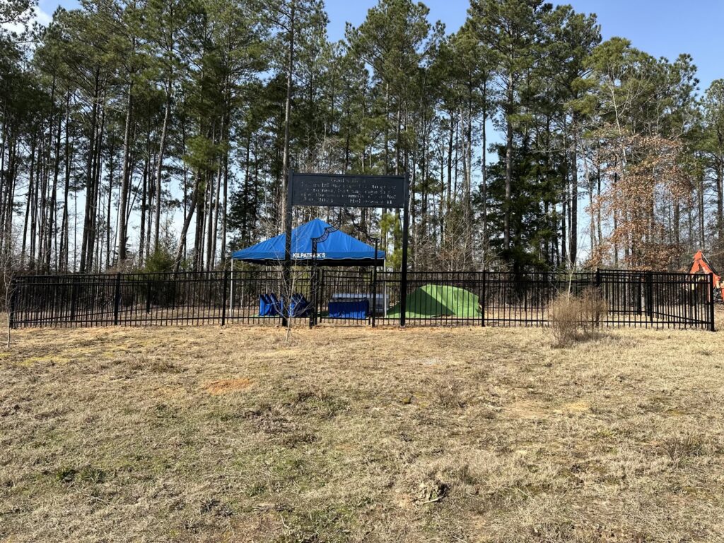 A newly installed black metal fence on a rural property by Lynch's Lawn & Fence LLC in Bossier City, LA.