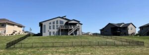 A black ornamental metal fence installed on a sloped residential property by The GateKeeper Perimeter Fence & Automated Security in Sioux Falls, SD