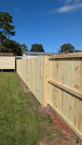 A custom black metal fence enclosing a large tree and small deck, installed by Gifford Contracting & Repair in Goose Creek, SC.