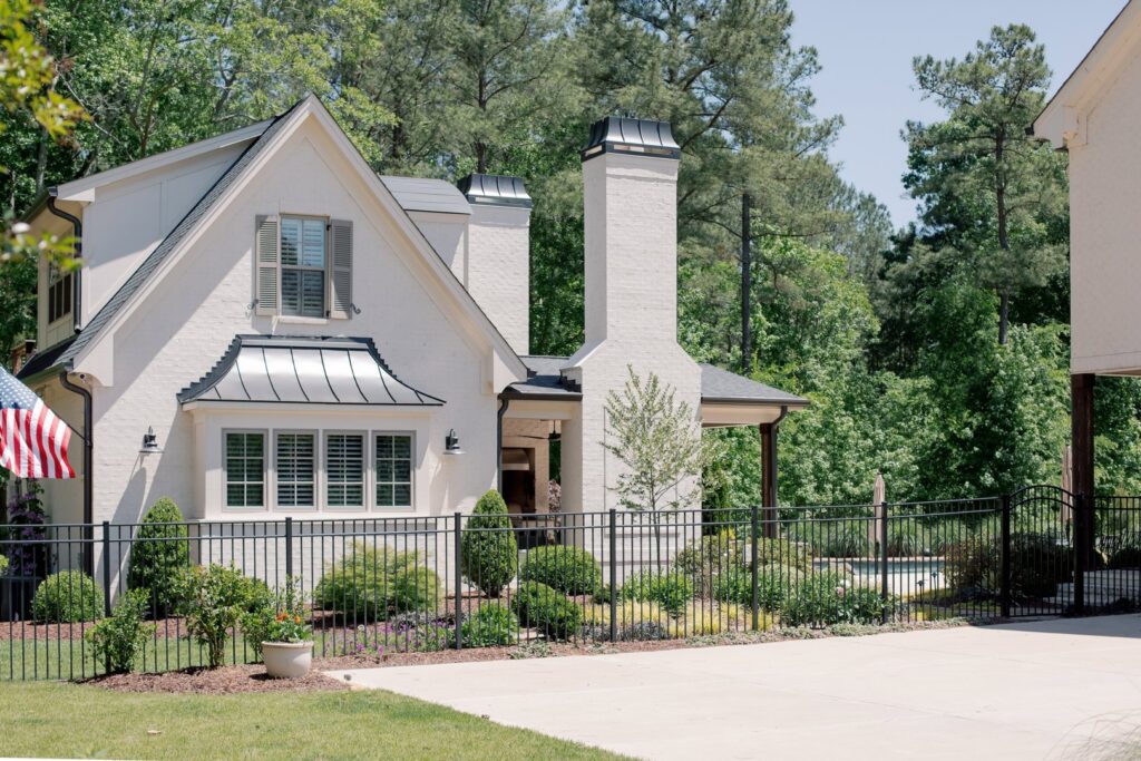 A black metal fence and gate complementing a white house by Heron Building Co in Franklin, TN.