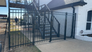 A black metal fence with a gate installed at a residential property by Goliath Fence Systems and Pre-Stain in Oklahoma City, OK.