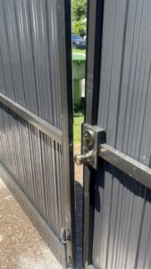 A close-up of a newly installed lock on a black metal gate by ARE FENCE LLC in Miami, FL.