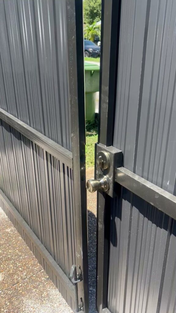 A close-up of a newly installed lock on a black metal gate by ARE FENCE LLC in Miami, FL.