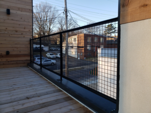 A modern black metal grid railing installed on a wooden deck or balcony by Missouri Ornamental Iron and Fence in St Louis, MO.