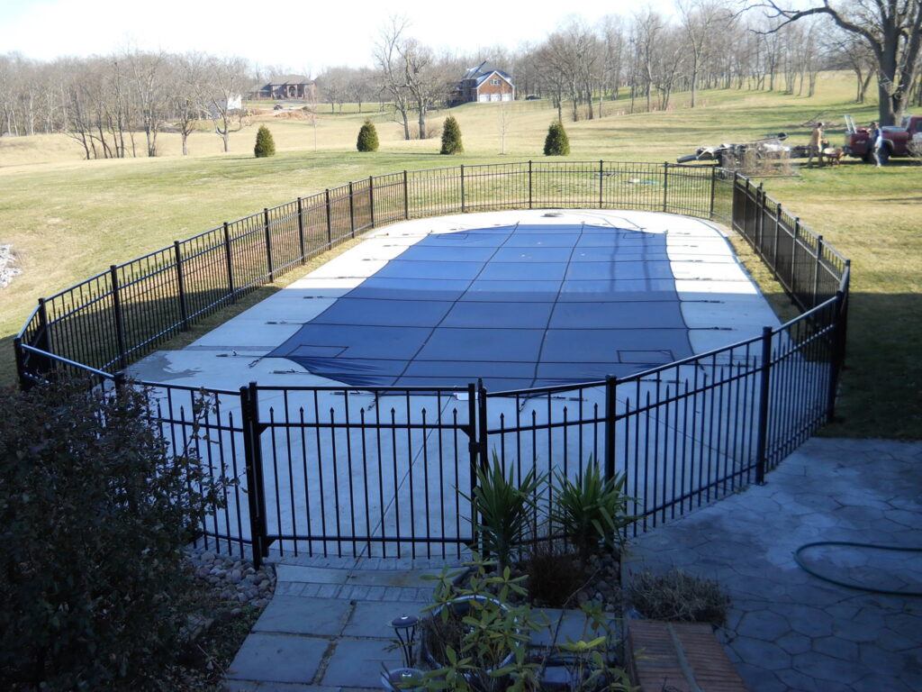 A black metal fence installed around an in-ground swimming pool by Border Built Fencing in Florence, KY.
