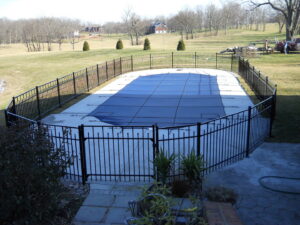 A black metal fence installed around an in-ground swimming pool by Border Built Fencing in Florence, KY.