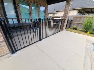A black metal fence installed to enclose a patio area next to a home by GOAT Fence Company in Houston, TX.