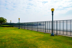 A long black metal perimeter fence bordering a green lawn, expertly installed by Columbia Fence Co. in Columbia Station, OH.