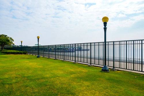 A long black metal perimeter fence bordering a green lawn, expertly installed by Columbia Fence Co. in Columbia Station, OH.