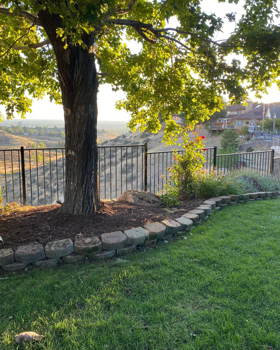 A black metal picket fence installed along a scenic hillside by ZBros Fencing LLC in Boise, ID.