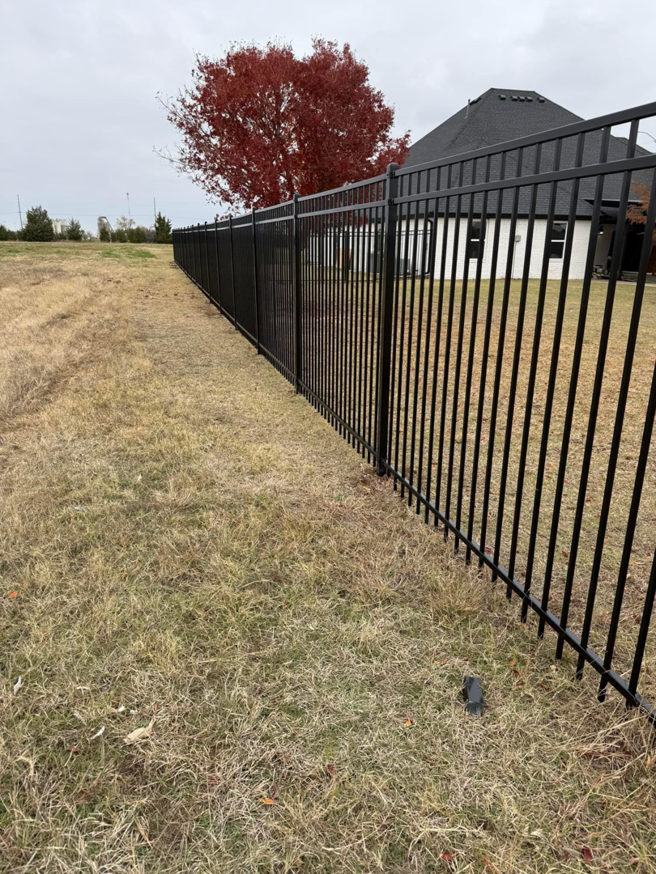 A black metal picket fence installed at a residential property by Goliath Fence Systems and Pre-Stain in Oklahoma City, OK.