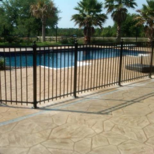 A newly installed black metal fence enclosing a swimming pool by Custom Fence Builders in Gulfport, MS.
