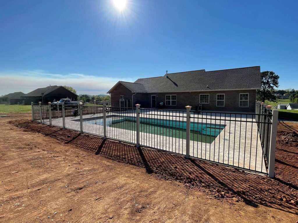 A new black metal fence installed around a swimming pool for safety and aesthetics by 865 Fencing in Knoxville, TN.