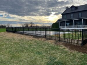 A black metal fence installed around a pool area by Premier Fence LLC in Canton, MA.