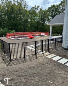A black metal fence installed around a pool area, demonstrating pool safety fencing by Teto's Fence Installation in Bridgeport, CT.