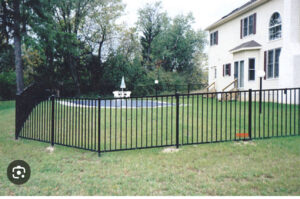 A black metal fence installed around a swimming pool by Liberty Fence & Stain in San Antonio, TX.