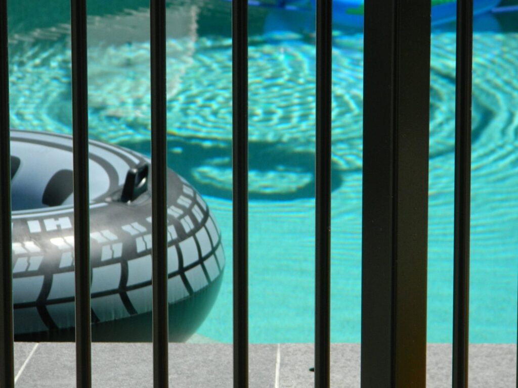 A black metal fence installed around a swimming pool by St. Charles Fence & Deck Company in Saint Peters, MO.