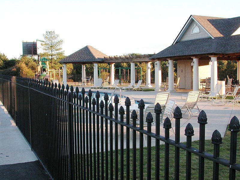 A black metal fence with decorative finials surrounding a swimming pool area by United Fence Company in Johnston, RI.