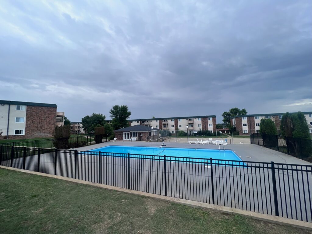 A black metal fence installed around a swimming pool area by Western Fence in Hebron, ND.