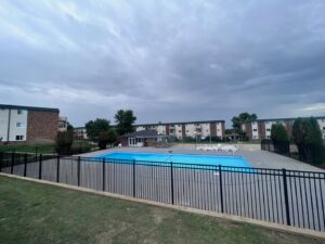 A black metal fence installed around a swimming pool area by Western Fence in Hebron, ND.