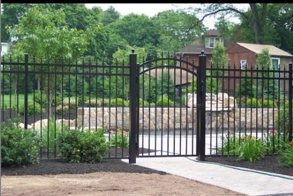 A black metal pool fence with an arched gate installed by Austintown Fence in Youngstown, OH.