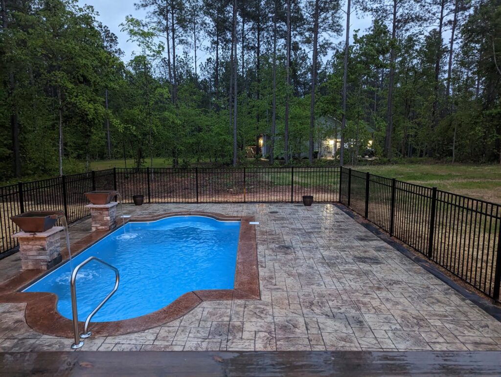 A black metal fence installed around a swimming pool for safety by Align Fence Builders in Durham, NC.