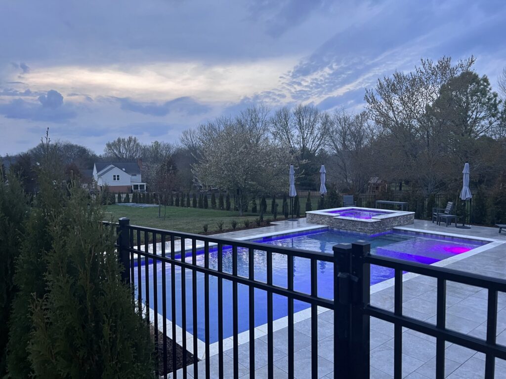 A black metal pool safety fence surrounding a residential swimming pool by America's Fencing in Nashville, TN.