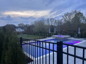 A black metal pool safety fence surrounding a residential swimming pool by America's Fencing in Nashville, TN.