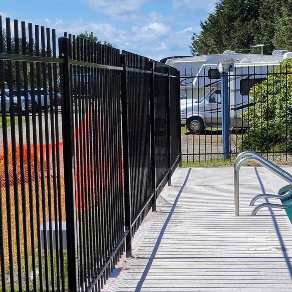 A black metal pool safety fence providing security around a swimming area, installed by PNW FENCE in Lewiston, ID.