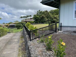 A custom black metal railing installed alongside a rockwall by Fence, Gates and Rockwalls in Kailua-Kona, HI
